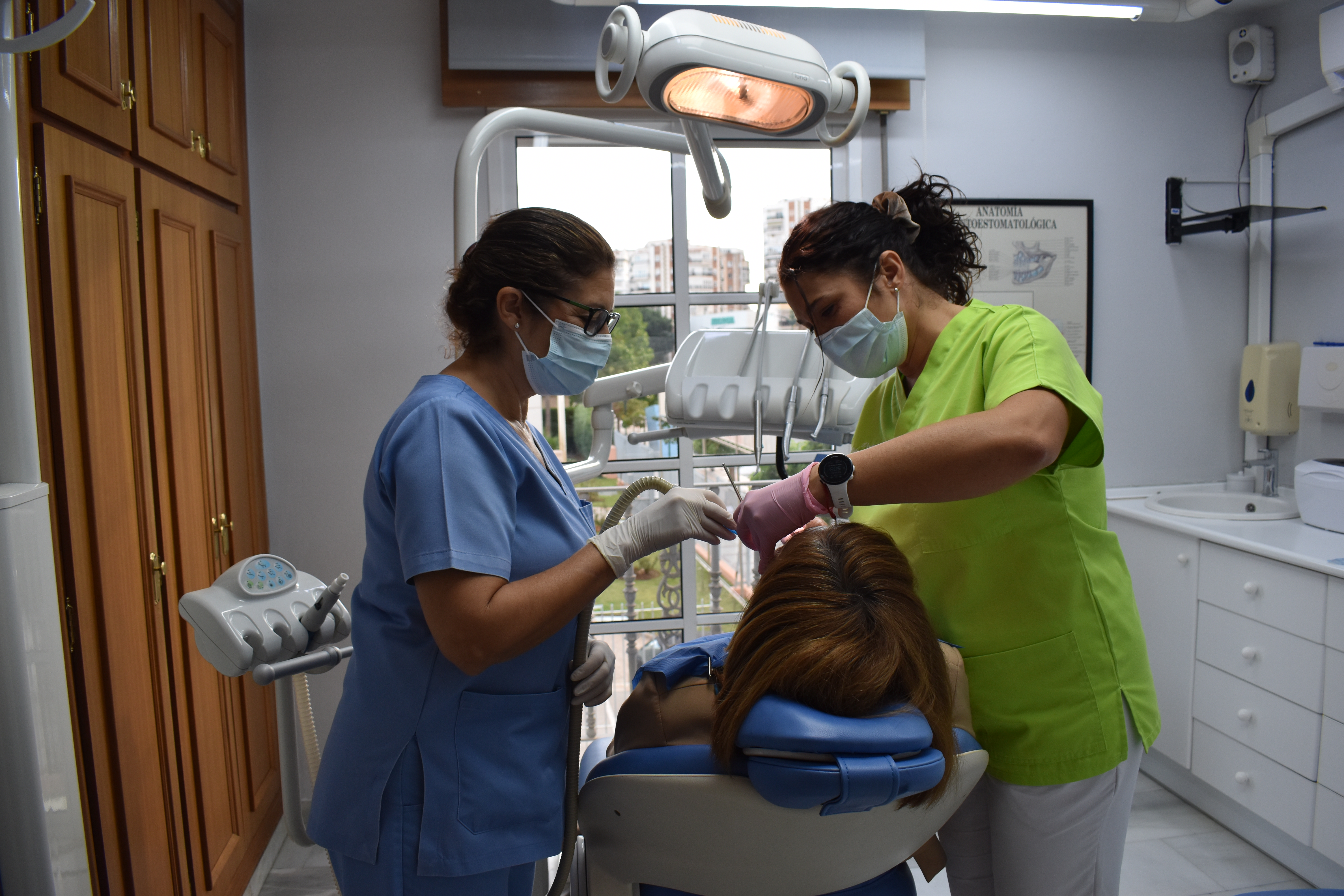 Equipo odontológico de CF Dental Clinic atendiendo a una paciente con un trato cercano y profesional.